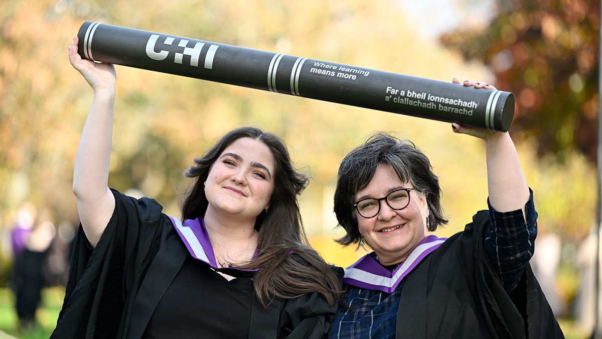 Alix and Margaret Aburn in gowns holding giant scroll Alix and Margaret Aburn in gowns holding giant scroll